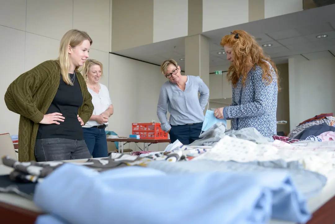 Teilnehmerinnen einer Nähaktion im Gespräch