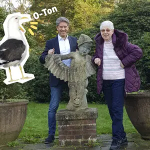 Link zu O-Ton: Margarete und Lars Müller. Margarete und Lars Müller stehen links und rechts einer Statue in einem Garten, Text "O-Ton", Grafik einer kreischenden Möwe