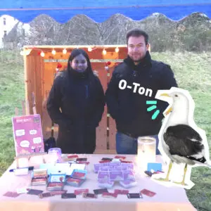 Link zu O-Ton: Deep Quest. Eine Frau und ein Mann aus dem Team Deep Quest stehen an einem Tisch mit ihrem selbst entwickelten Kartenspiel