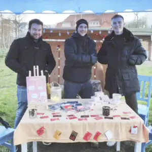 Drei junge Männer aus dem Team Deep Quest stehen an einem Tisch mit ihrem selbst entwickelten Kartenspiel