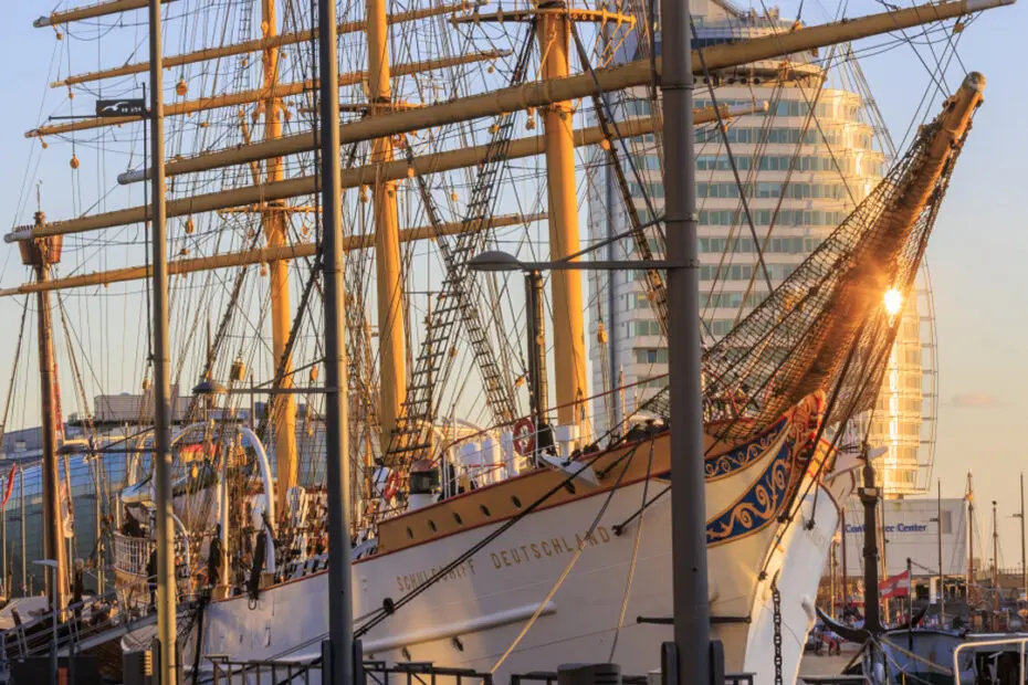 Schulschiff Deutschland an der Kaje, im Hintergrund spiegelt sich die Sonne im Atlantic Hotel Sail City