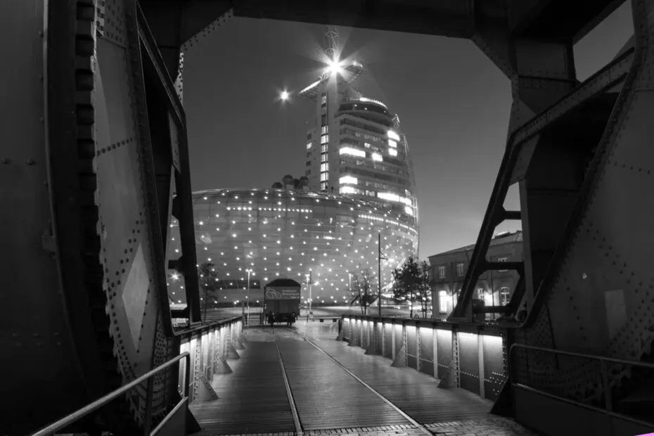 Schwarz-Weiß-Aufnahme vom erleuchteten Klimahaus Bremerhaven und dem Atlantic Hotel Sail City